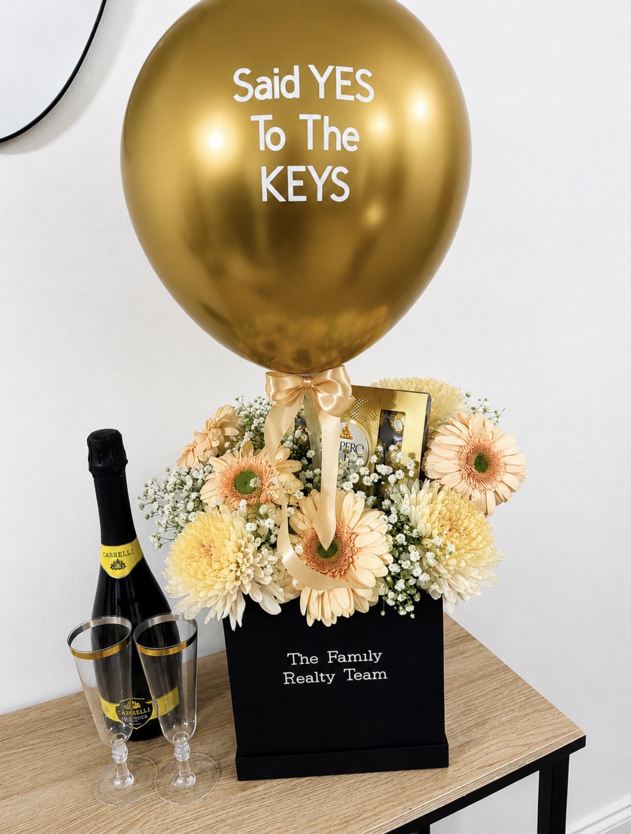Gold housewarming balloon gift box with flowers and champagne