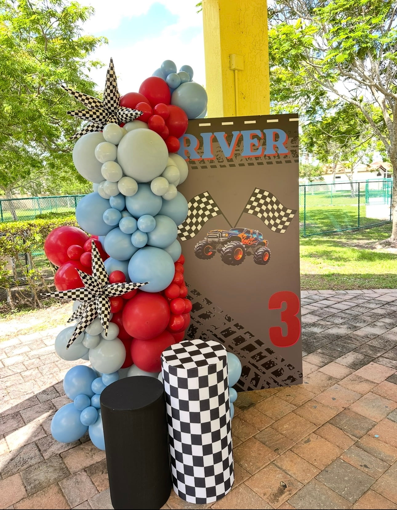 Monster truck racing birthday balloon column in red and blue