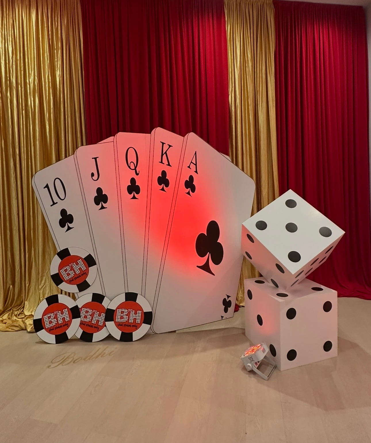 Giant playing cards and dice backdrop with red and gold drapes