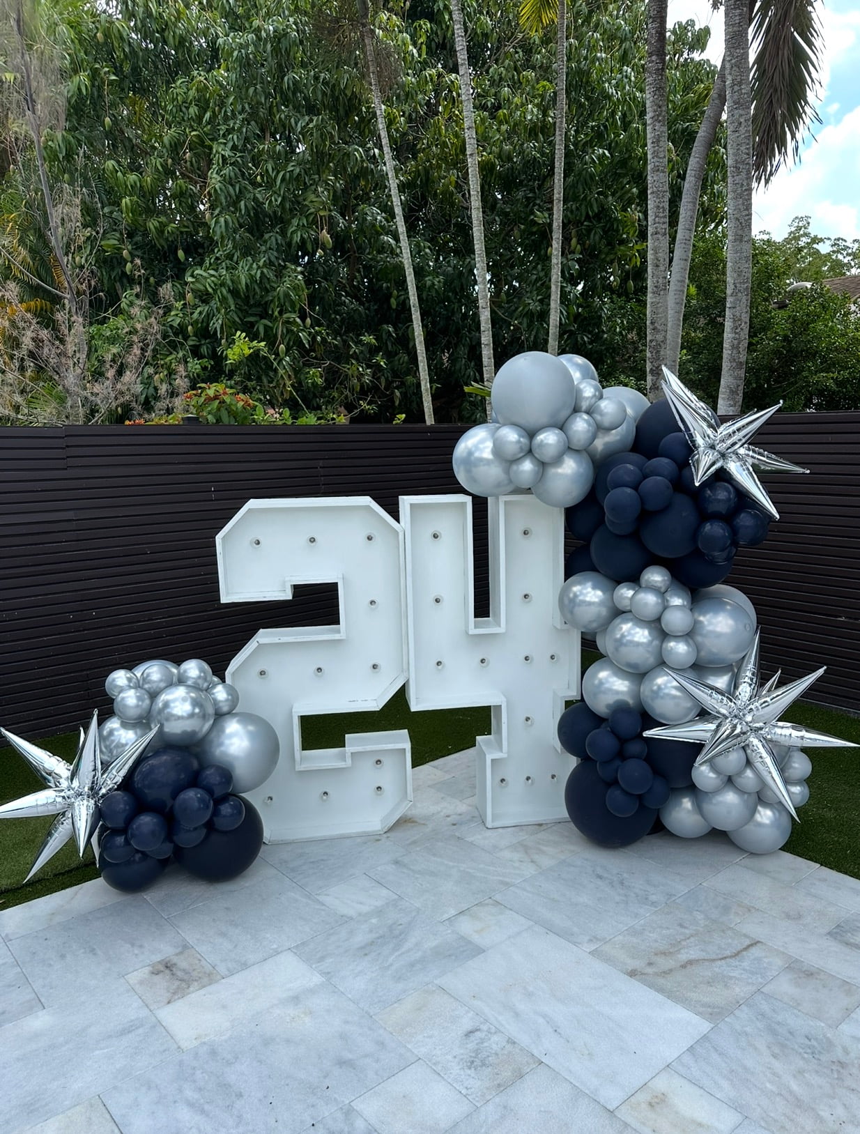 Modern 24th birthday display with silver and navy balloon clusters